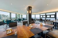 a dining room with tables and chairs and windows at STANFORD Hotel & Resort Jeju in Jeju