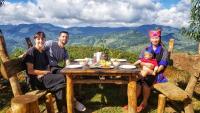 un grupo de personas sentadas en una mesa con un bebé en A Su Homestay Mù Cang Chải, en Mù Cang Chải