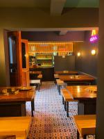 une salle à manger avec des tables en bois et un bar dans l'établissement Suites Cárdon, à Oaxaca