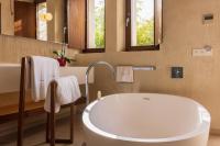 a bathroom with a large tub and a mirror at Hotel Rural Xereca in Puig D’en Valls