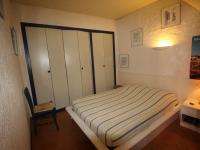 a small bedroom with a bed and a chair at Studio Collioure, 2 pièces, 4 personnes - FR-1-309-153 in Collioure