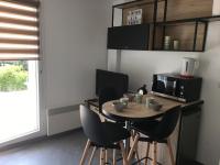 a kitchen with a table with chairs and a microwave at Studio Merville-Franceville-Plage, 1 pièce, 3 personnes - FR-1-487-222 in Merville-Franceville-Plage