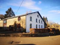 a white brick house sitting on the side of a street at Gîte Les trois charmes in Gouvy