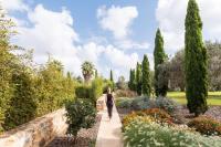 a woman walking through a garden at Hotel Rural Xereca in Puig D’en Valls