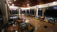 een eetkamer met tafels en stoelen en ramen bij La Kamp Resort in Bhuj