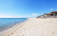 a beach with umbrellas and the ocean at Amazing Apartment In Saint Cyprien Plage With Wifi in Saint-Cyprien-Plage