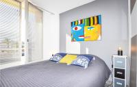 a bedroom with a bed and a painting on the wall at Amazing Apartment In Saint Cyprien Plage With Wifi in Saint-Cyprien-Plage