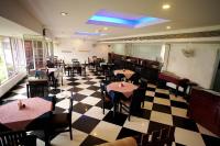 a restaurant with tables and chairs on a checkered floor at AQUARIA THE BOUTIQUE RESORT in Cochin
