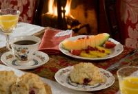 Una mesa con dos platos de fruta y una taza de café. en Hampton Terrace Inn, en Lenox
