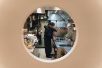 a man standing in a kitchen preparing food at Hotel Morfeo in Milan