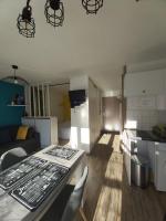 a kitchen and a living room with a table and chairs at Luz St Sauveur, Appartement 3 personnes, vue montagne, exposé sud, Résidence très calme in Luz-Saint-Sauveur