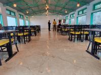 Dois homens numa sala com mesas e cadeiras. em LaSerene The Cottage - Pangoot em Nainital