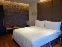 a large white bed in a room with a brick wall at Fu Wan Cafe Villa in Donggang