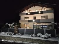 a building at night with snow in front of it at groassehof Haus Gstrein in Imsterberg