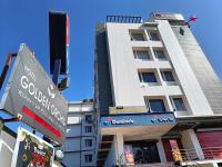 un edificio blanco alto con señales delante en HOTEL GOLDEN ORCHID, en Dibrugarh