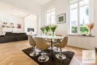 una sala de estar blanca con mesa y sillas en Hôtel particulier - Le 119, en Valenciennes