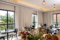 a restaurant with tables and chairs and large windows at Hotel Botanica- Limited Edition By Fattal in Haifa