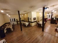 Una gran sala con mesas y sillas en un edificio. en Forest Inn, en Izvorani