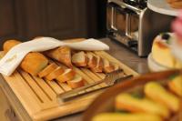 Una tabla de cortar con pan y un cuchillo y un montón de pan. en Crona SPA Karpaty, en Skhidnytsya