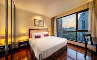 a hotel room with a bed and a large window at Bandara Suites Silom, Bangkok in Bangkok
