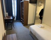 a hotel room with a bed and a desk and a table at Hotel Moderne in Vichy