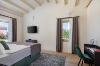 ein Schlafzimmer mit einem Bett, einem Schreibtisch und einem Fenster in der Unterkunft Villa Grace by ILC (Istria Luxury Collection) in Brtonigla