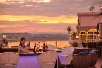 a woman sitting at a bar with bottles of wine at Eastin Hotel Vientiane in Vientiane