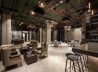 a restaurant with chairs and tables and a bar at Eastin Hotel Vientiane in Vientiane