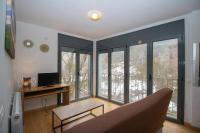 Una sala de estar con un sofá y algunas ventanas. en Apartamentos Canillo 3000, en Canillo