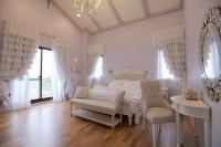 a white bedroom with a bed and a chair at Happiness Pass On in Wujie