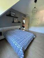a bedroom with a bed with a blue and white bedspread at L&#39;écureuil de la Baie - maison en Baie de Somme in Mons-Boubert