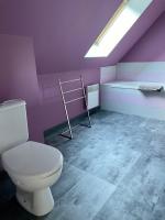 a bathroom with a toilet and a purple wall at L&#39;écureuil de la Baie - maison en Baie de Somme in Mons-Boubert