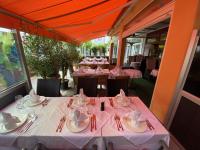 une salle à manger avec des tables avec des nappes roses dans l'établissement Hotel Ristorante La Terrazza, à Planegg