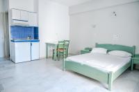 a bedroom with a bed and a kitchen with a table at Korali Garden in Naxos Chora