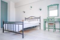 a bedroom with a bed and a table and a mirror at Korali Garden in Naxos Chora