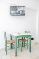 a green table and chairs with a tv on the wall at Korali Garden in Naxos Chora