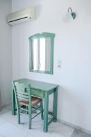 a green table with a chair and a mirror at Korali Garden in Naxos Chora