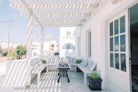 a porch with white chairs and a table at Korali Garden in Naxos Chora