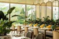 Un restaurante con mesas, sillas y plantas. en The Fullerton Ocean Park Hotel Hong Kong, en Hong Kong