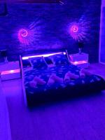 a bed in a room with purple lights at La marbrière, Parking gratuit, proche centre ville in Sens
