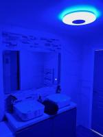 a bathroom with two sinks and a blue light at La marbrière, Parking gratuit, proche centre ville in Sens