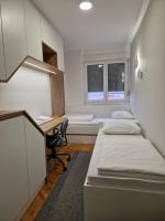 a room with two beds and a desk and a window at Superbia Osijek - SELF CHECK-IN in Osijek