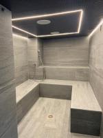 a bathroom with a tub with a shower at Hôtel Alpina &amp; SPA in Les Gets