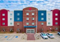 Un edificio con coches aparcados en un estacionamiento. en Candlewood Suites Lafayette by IHG, en Lafayette