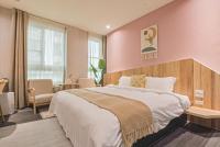 a bedroom with a large bed with a pink wall at Ashare Hotel in Jiaoxi