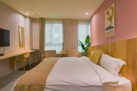a bedroom with a large bed with a pink wall at Ashare Hotel in Jiaoxi