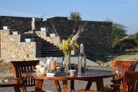 a wooden table with a vase of flowers on it at Clarks Safari Jawai in Jawāi Bāndh