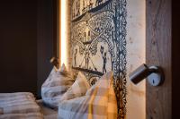 a bed with a black and white headboard and pillows at Panorama Hotel &amp; Restaurant in Bettmeralp