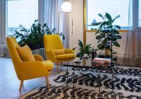 a living room with two yellow chairs and a coffee table at Hotel Sparre in Porvoo