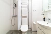 a white bathroom with a toilet and a sink at Hotel Sparre in Porvoo